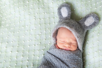 Cute sleeping newborn baby dressed like Easter bunny