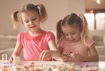 Fototapeta premium Girls playing at home. Girls playing with Bricks at home.