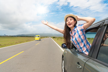 female tourist in car on road trip showing hand