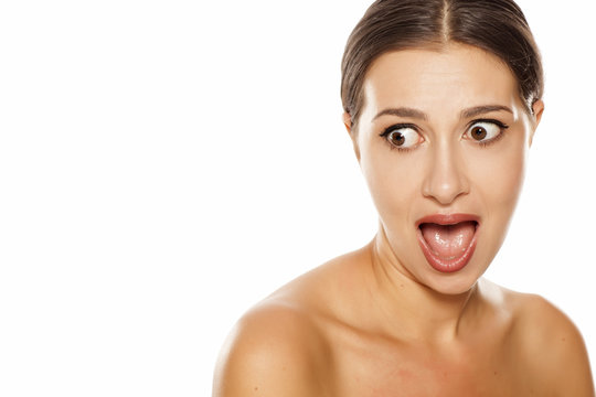 Portrait of shocked young woman on white background