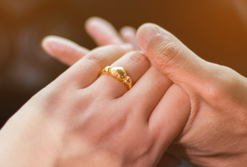 Gold ring on the finger of a woman showing love.