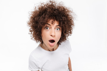 Close up of amazed young woman with curly hair