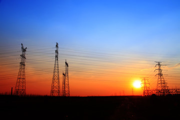 The silhouette of the evening electricity transmission pylon