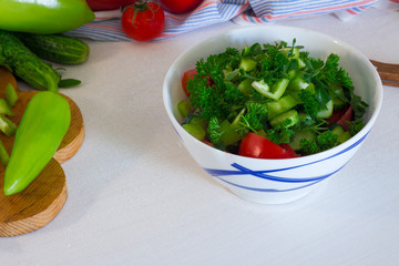 Salad fresh tomatoes, cucember, parsley, pepper on white table