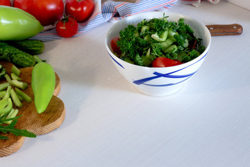 healthy food - salad with fresh vegetables in white bowl on white table