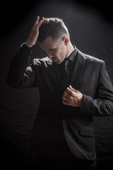Fototapeta premium man sexually removes clothes on a dark background