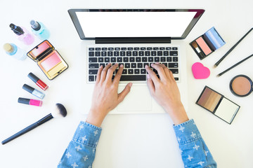 top view of women using laptop for searching cosmetic information for makeup, beauty concept.