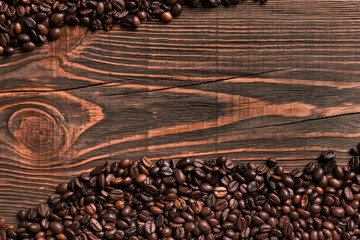 Coffee beans on wooden table texture with copy space. View from 