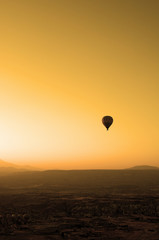 ballooning. A balloon flies in the sky in the rays of the rising sun. A bright sky, a haze, an extinct volcano on the horizon.