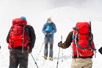 A team of climbers led by a guide discusses the upcoming ascent
