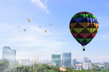 Aerostat floating in day sky. Mixed media