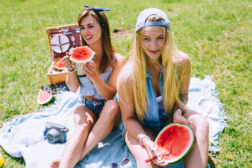 Two beautiful girls eating watermelon for a picnic