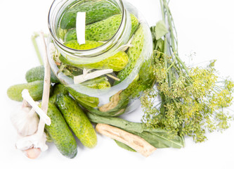 Brined pickles in a jar, with all  the ingredients for  making them (garlic, dill and horseradish)