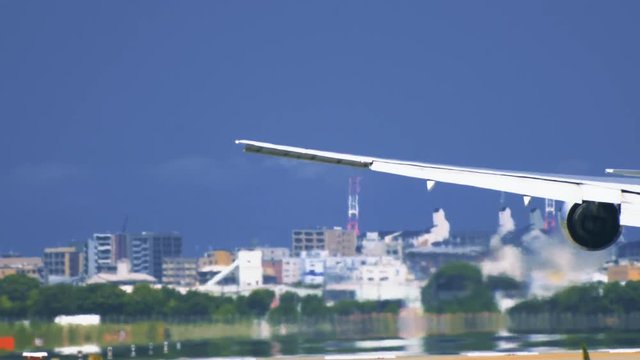 Airplane touchdown on airport runway from behind in extremely closeup
