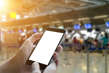 A man hand holding empty screen of smart phone and check-in counter airport terminal background.