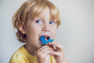 Three-year old boy shows myofunctional trainer to illuminate mouth breathing habit. Helps equalize the growing teeth and correct bite. Corrects the position of the tongue - obrazy, fototapety, plakaty
