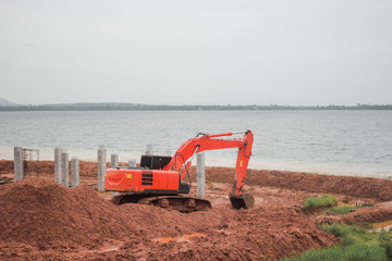 Backhoe loader digging on the shore.