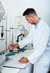 Naklejka na ściany i meble attentive man making tests in wine manufactory laboratory