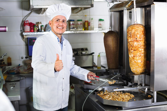 Man cook making kebab dish and looking satisfied holding thumbs up