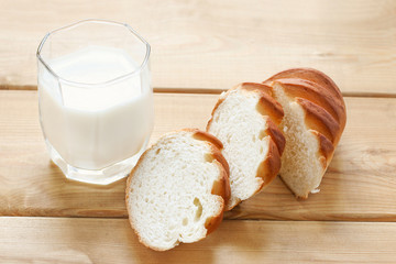 glass of milk and white bread on wooden background