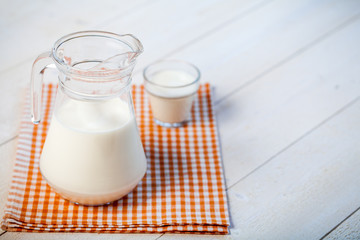 jug of milk on a wooden rustic table. copy space