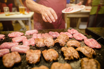 Salsiccia e salamella in cottura sulla piastra, alla griglia