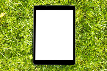 Tablet Computer on the Green Grass at the sun, isolated white screen, empty space for trext, copy...