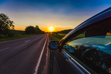 Fototapeta na wymiar Car on the side of the road sunset