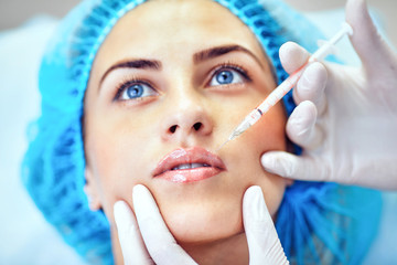 Woman with marked face receiving botox injection