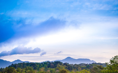 Clouds drifting over forests and mountains