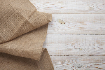 Canvas napkin with lace. Burlap hessian sacking on white wooden table background top view
