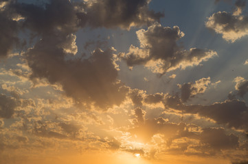 Fototapeta na wymiar Beautiful sunset or sunrise with sun and orange, grey dark clouds on the blue sky