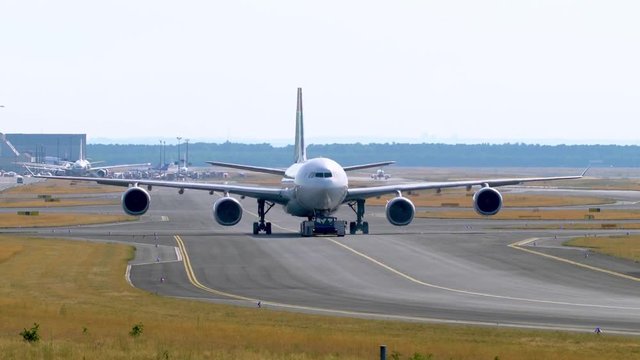 Tow Tractor towing a passenger plane on the runway of the airfield