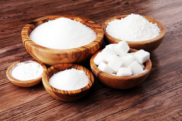 Obraz na płótnie Canvas Sugar composition with white sugar in bowls on wooden board