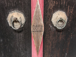 Detail of poor handles on an old temple door, Thailand