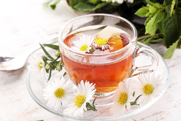 cup of tea with chamomile flowers on rustic background