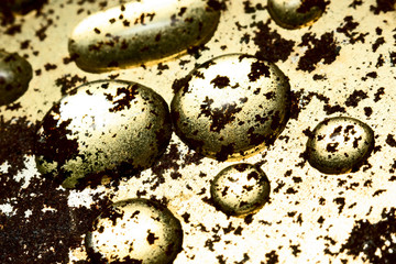 Obraz premium Water drops macro on a gold rusty background