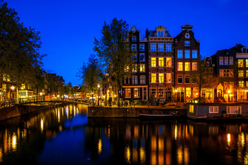 Fototapeta premium Night shot of the city, many bicycles on the bridge on Amsterdam canal, Netherlands