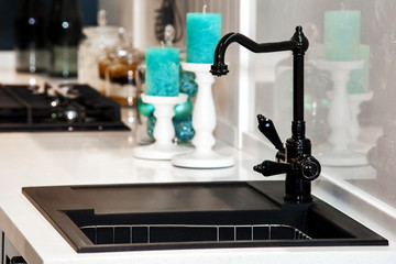 Black kitchen sink and faucet in room interior