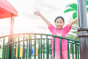 Happy asian girl playing on children playground