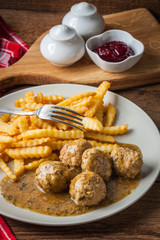 Meatballs with french fries in dill sauce.