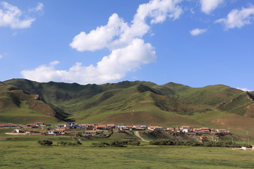 green landscape and mountains surrounding village,Gansu Province,China