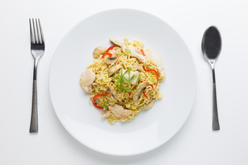 Stir-fry noodles with chicken meat, mushroom and red capsicum in a plate on white background top view