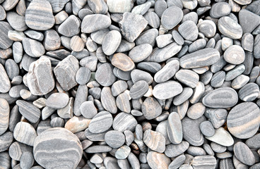 Abstract grey dry round stones background. At the beach. Sea pebbles and gravel style. Top view....