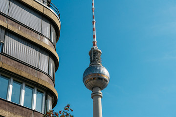 tv tower at berlin next to an office building
