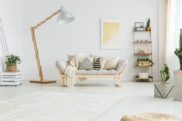 Beige coverlet lying on grey sofa