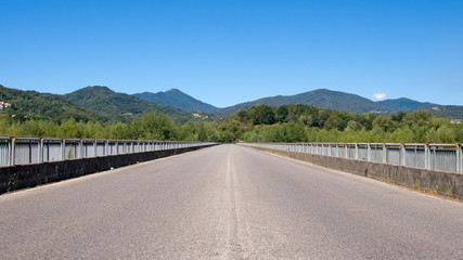 Straight road to horizon. No traffic, sunny day.