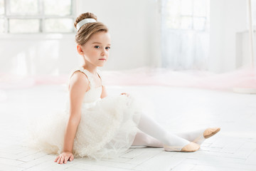 The little balerina in white tutu in class at the ballet school © master1305