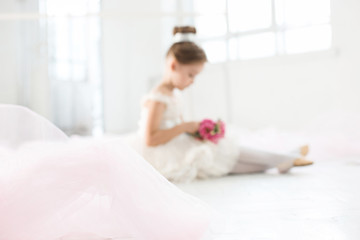 Obraz na płótnie Canvas The little balerina in white tutu in class at the ballet school