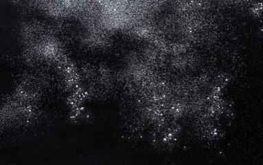 Baking concept on black background, sprinkled flour with copy space